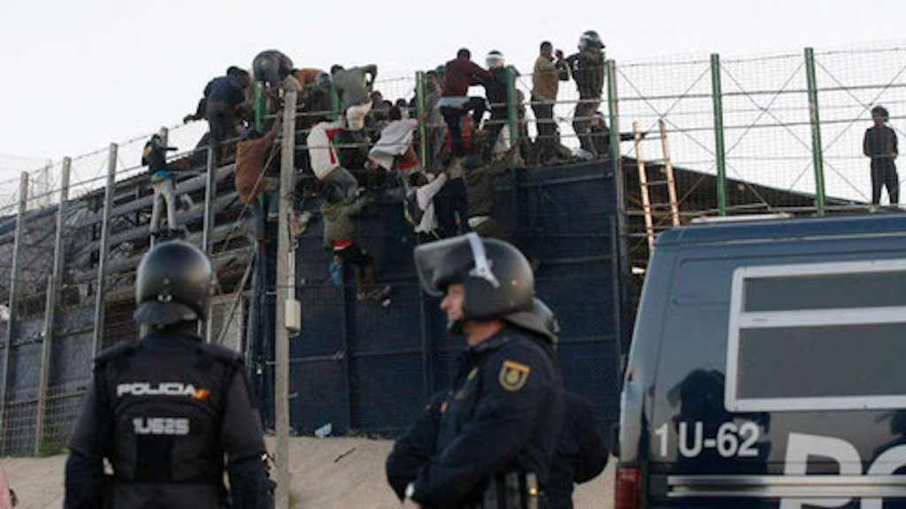 inmigrantes saltando la valla y la bric vigilante